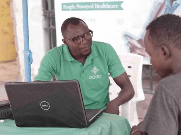 A DOGO team member registering a visitor at a community stand.